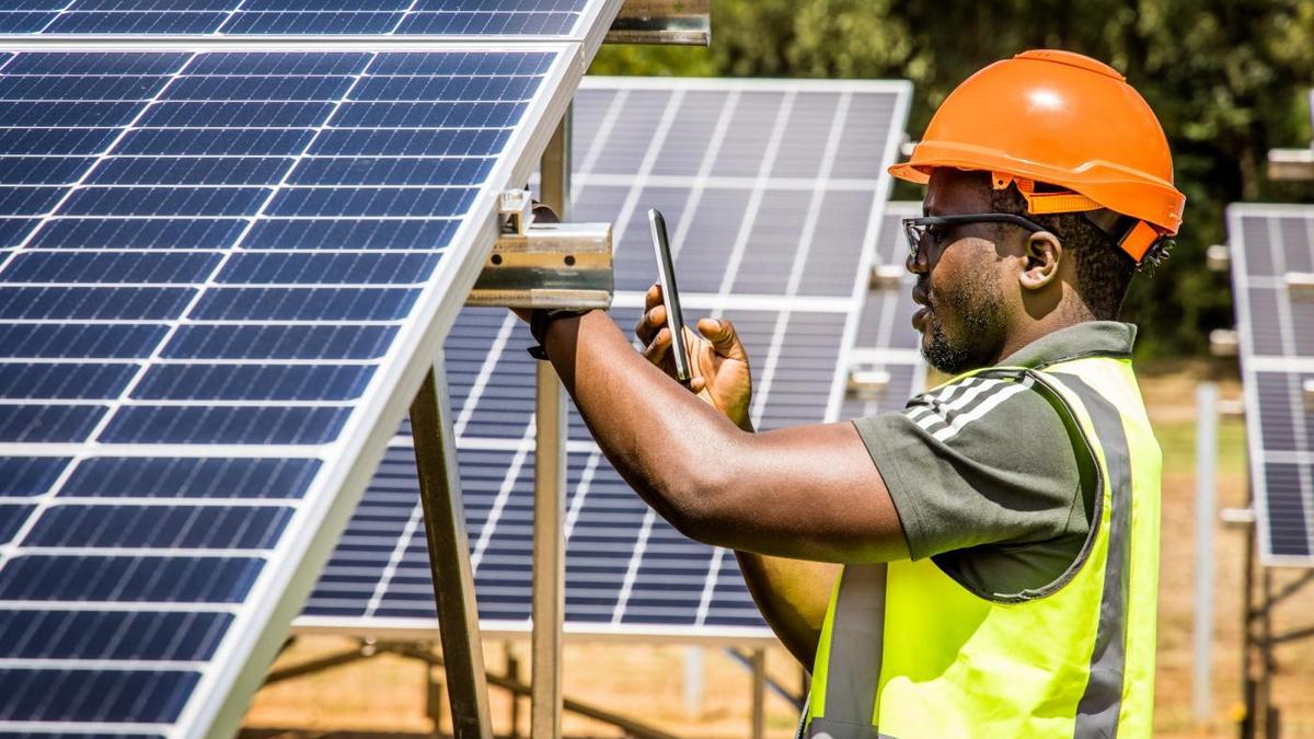 image d'un technicien africain qui fait l'inspection de panneaux solaires photovoltaique - énergies renouvelables